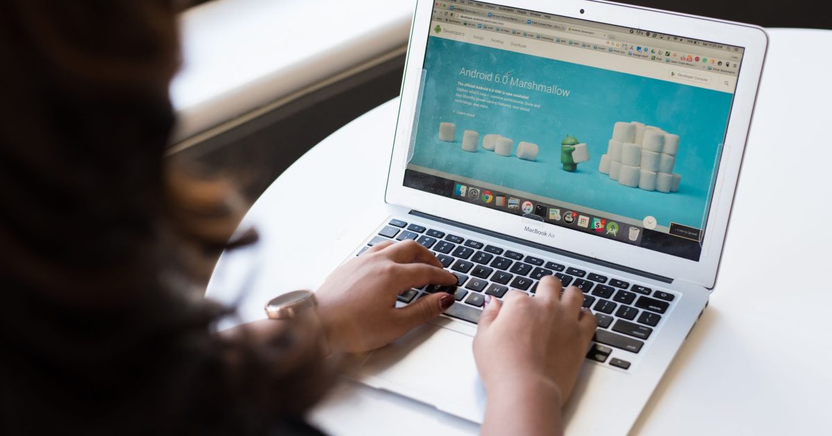 A person typing on a laptop with a web browser open