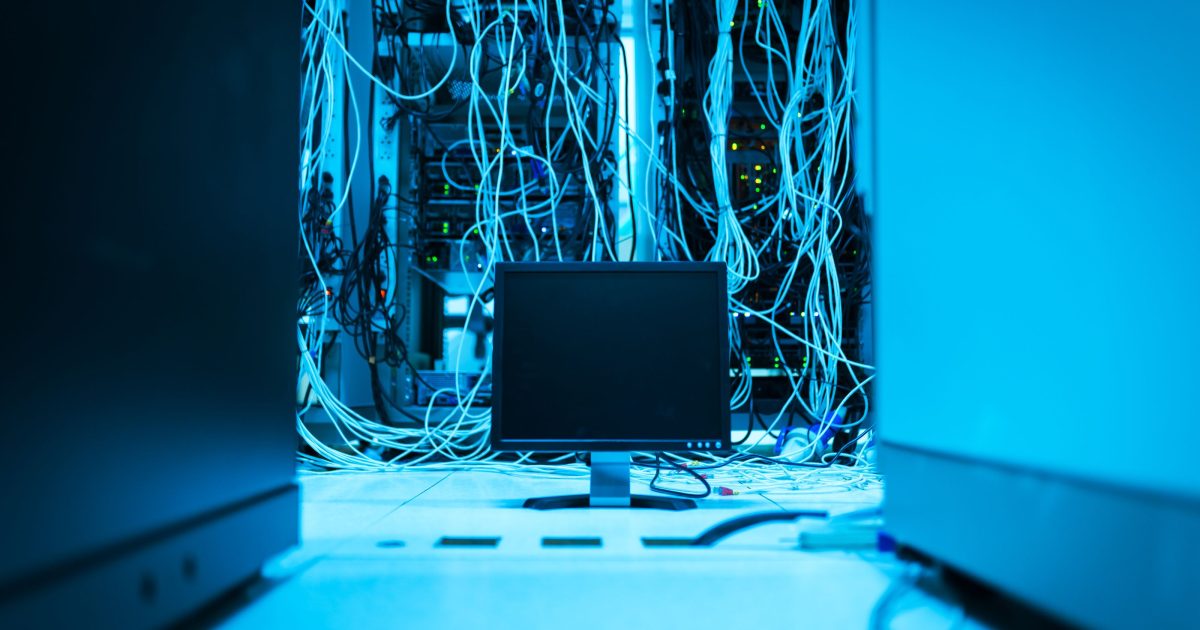 A rack of network equipment lit in blue, with patch cables running between devices