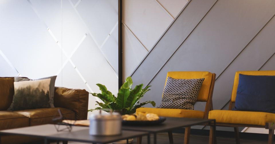 A living room with a sofa, two yellow armchairs and a low coffee table